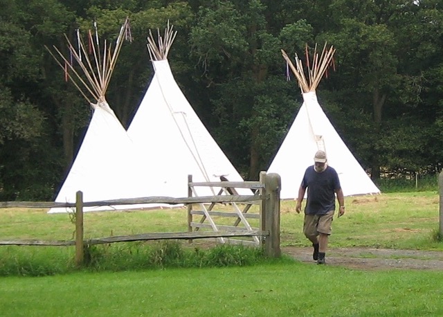 3 tipis with man walking through gate